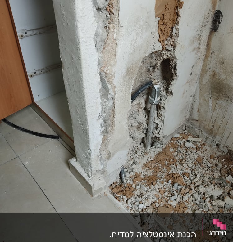 קיר שבור עם צינור מים חשוף ותשתית בנייה